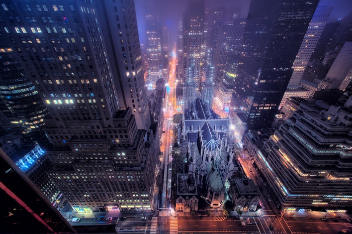 New York City skyline at night with a cathedral