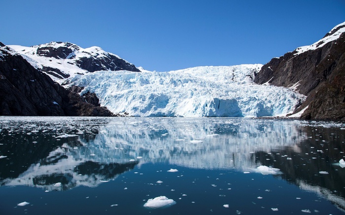 Glacier calving into the ocean with icebergs