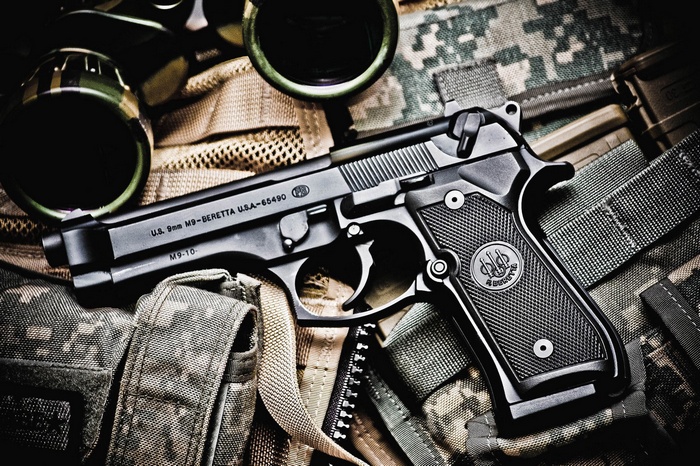 Beretta M9 9mm Pistol on Camouflage Gear