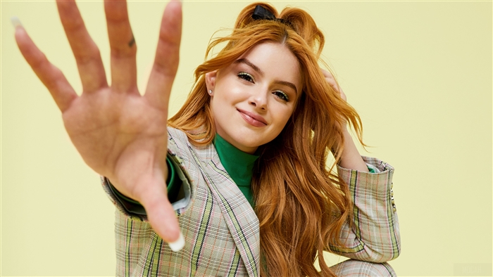Ariel Winter smiling and holding up her hand