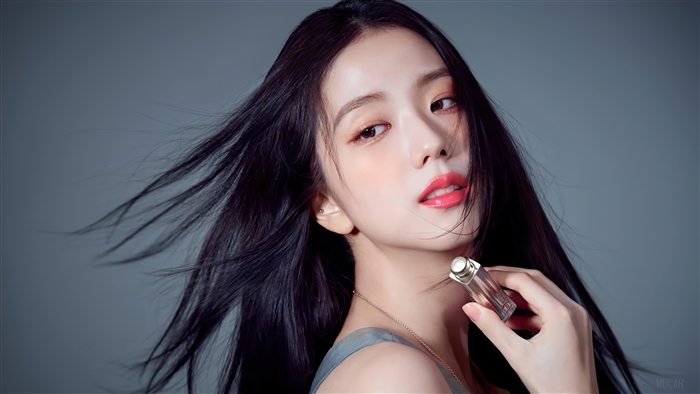 Jisoo from BLACKPINK holding a perfume bottle