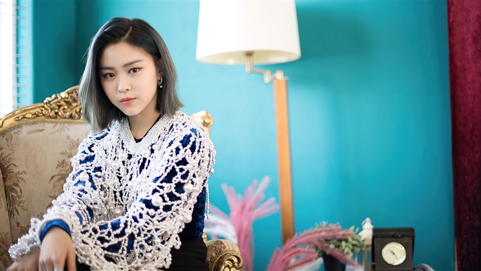 Ryujin from ITZY sitting on a chair