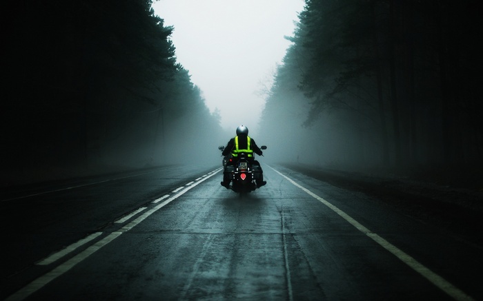 Motorcyclist on a foggy road