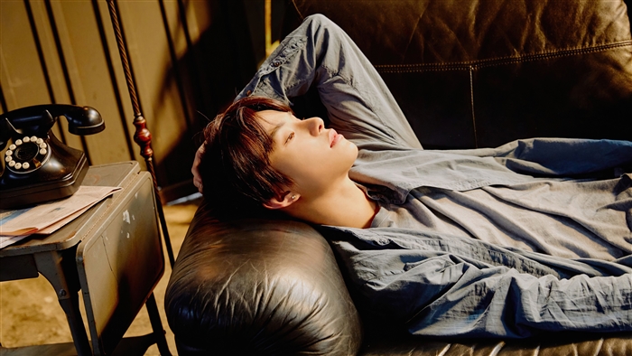 Jungwoo from NCT 127 lying on a couch