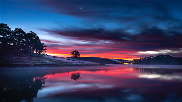Sunset over a misty lake with reflections