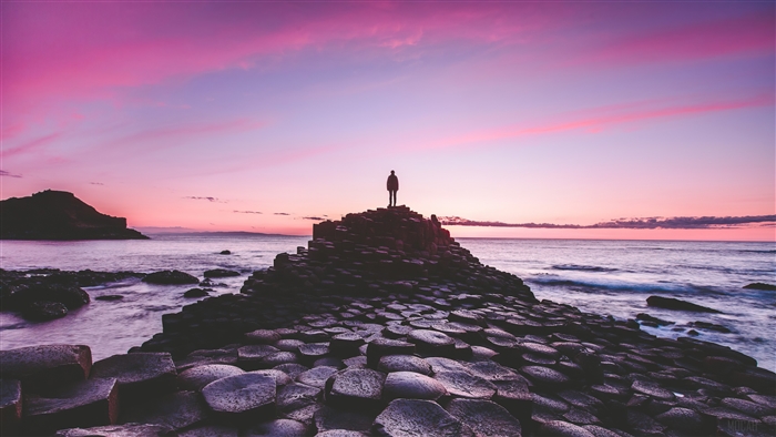 Man standing on Giant's Causeway at sunrise 4K