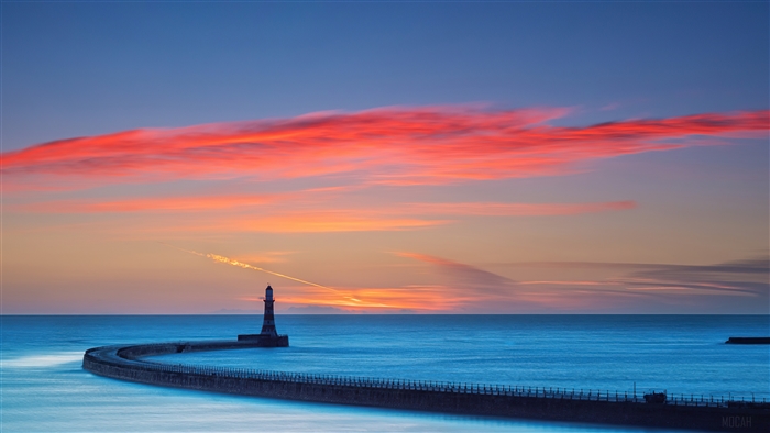 Lighthouse on a pier at sunset with colorful clouds