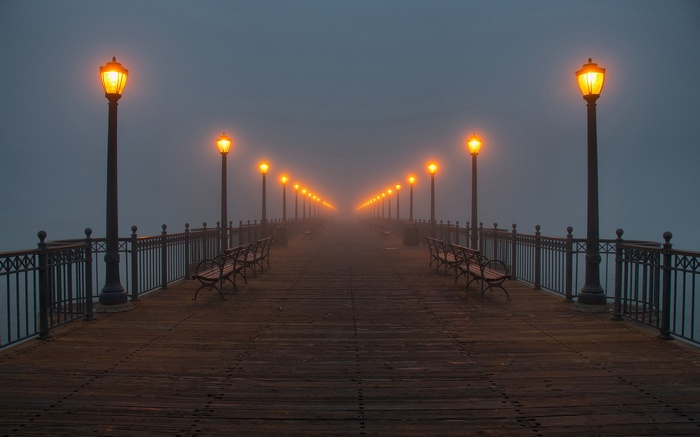Foggy Pier with Illuminated Lamps at Dusk
