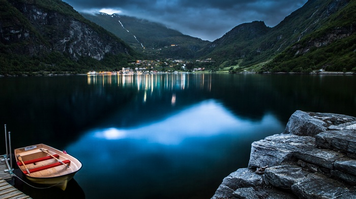 Boat docked on a lake with a village in the background