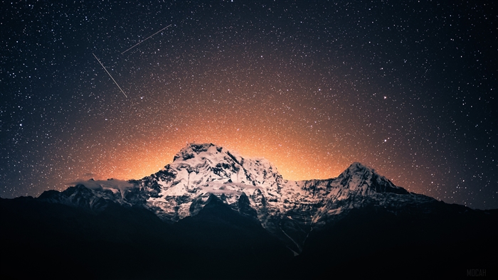 Snow-capped mountains under a starry night sky