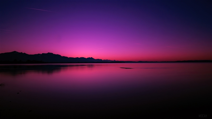Sunset over a lake with mountains and purple sky 4K