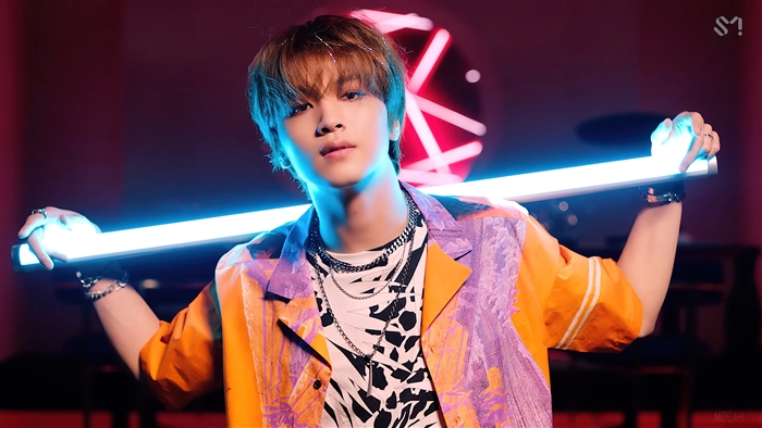 Haechan from NCT Dream holding a light stick