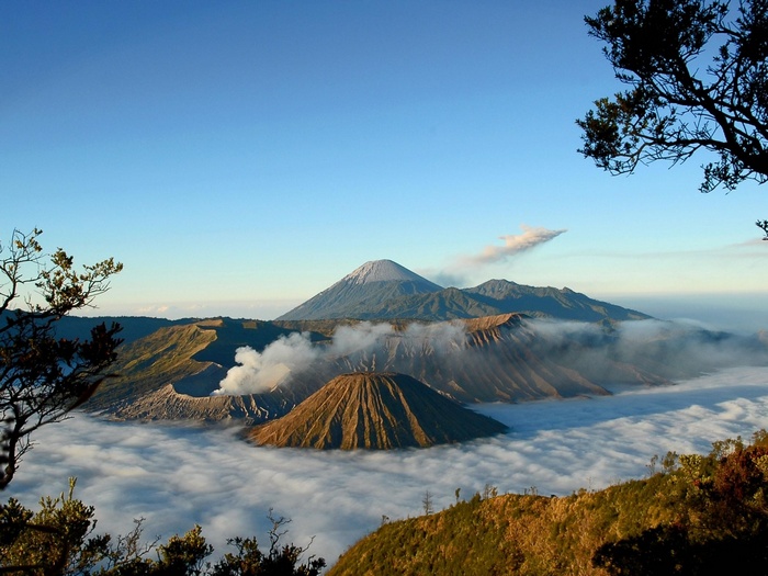 Volcanoes erupting with clouds over a sea of clouds