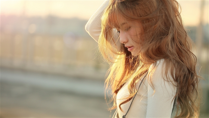 Sunlit Woman with Flowing Brunette Hair in Soft Focus