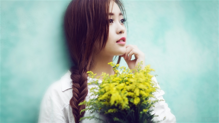 Young woman with braided hair holding yellow flowers