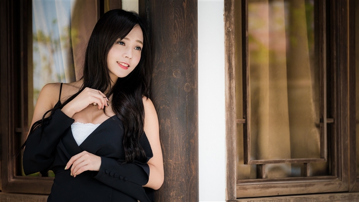 Asian woman with black hair and blue eyes in black dress