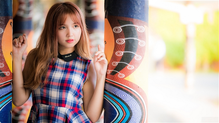 Young Woman in Plaid Dress with Colorful Pillar