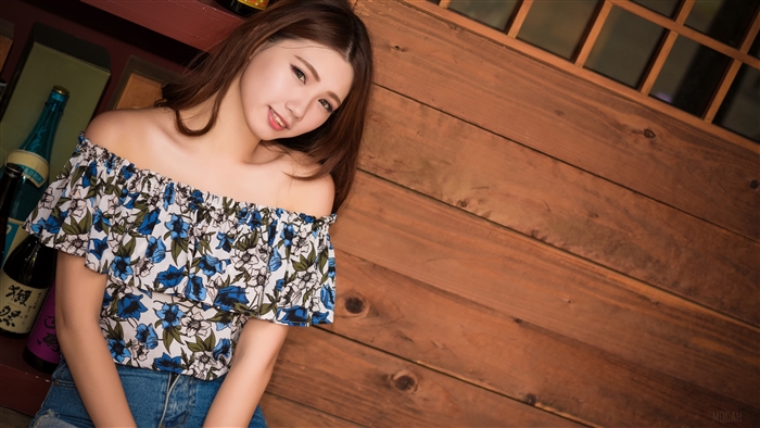 Woman in floral off-the-shoulder top and jeans