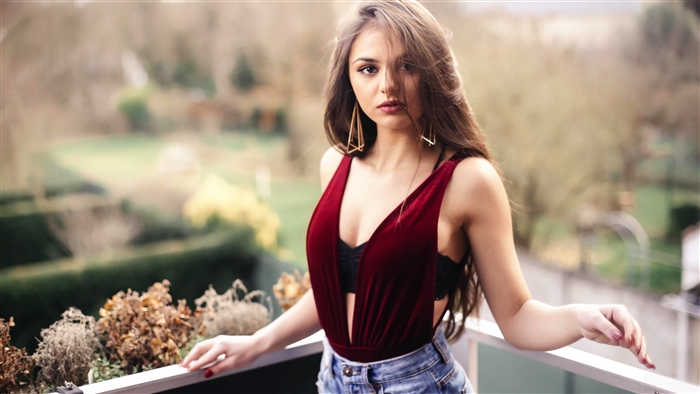 Brunette woman with earrings on a balcony