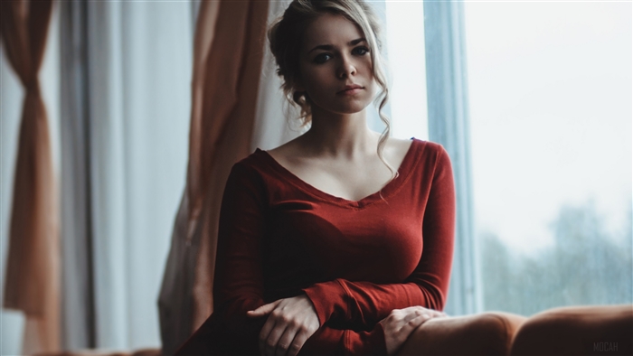 Woman in red dress by window