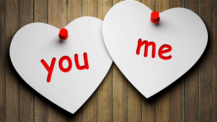 Two heart-shaped papers with "you" and "me" written on them