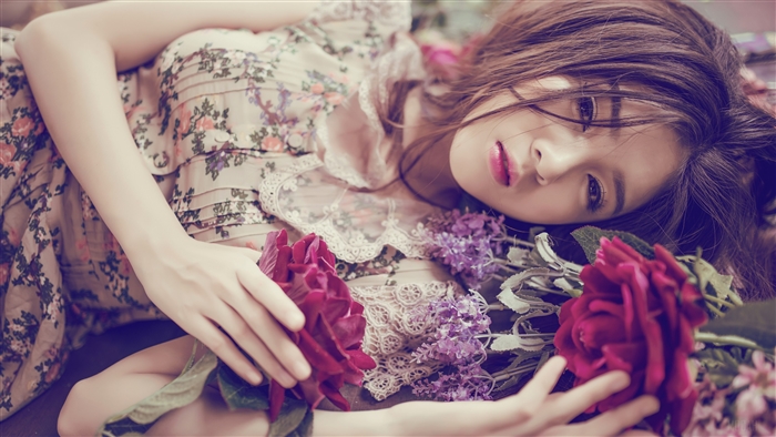 Woman in floral dress lying down with flowers