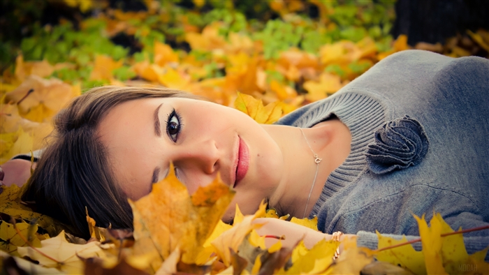 Woman lying in autumn leaves
