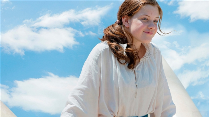 Girl in white shirt against blue sky with clouds