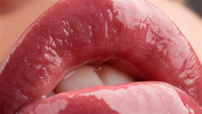 Close-up of glossy red lips with teeth showing