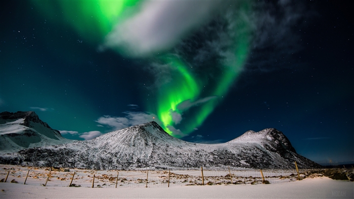 Aurora Borealis over snow-covered mountains in Lofoten Islands, Norway 4K