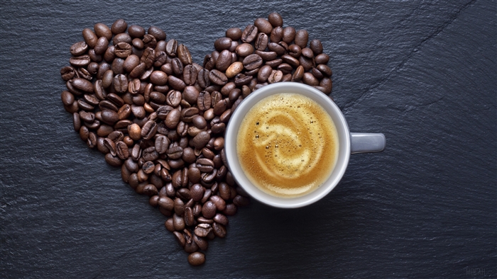 Coffee beans in a heart shape with a cup of coffee
