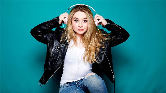 Sabrina Carpenter wearing headphones and leather jacket