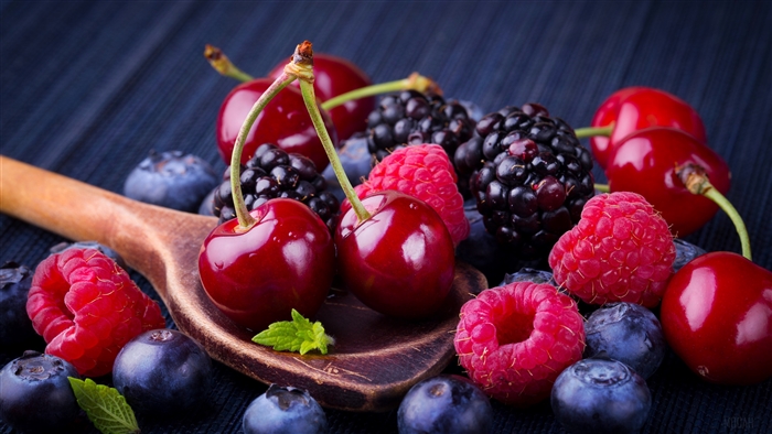 Assortment of Fresh Berries and Cherries on a Wooden Spoon