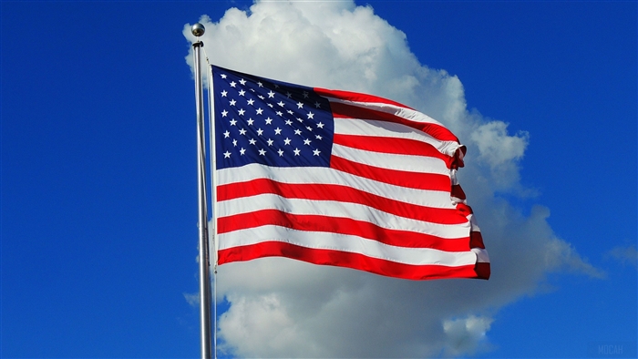 American Flag Waving Against Blue Sky with Clouds