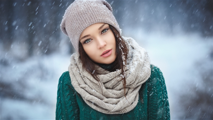 Woman in winter hat and scarf in snow