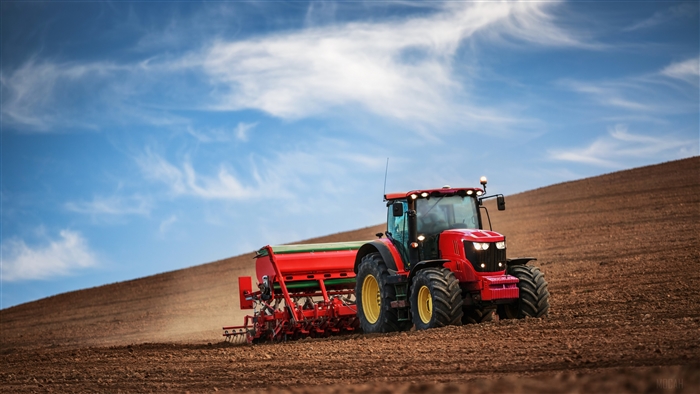 Red Tractor Working in a Field under Blue Sky 4K