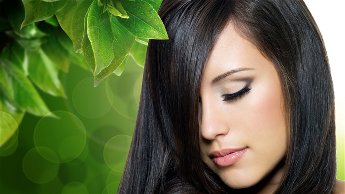 Woman with dark hair and green leaves