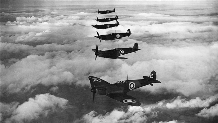 Squadron of Spitfire Aircraft Flying Above Clouds