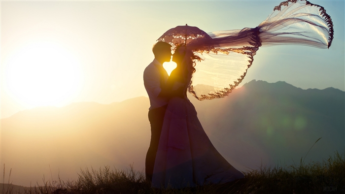 Couple kissing under an umbrella at sunset 4K