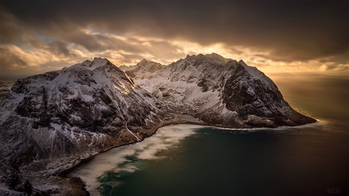 Snowy Mountains Overlooking a Bay at Sunset