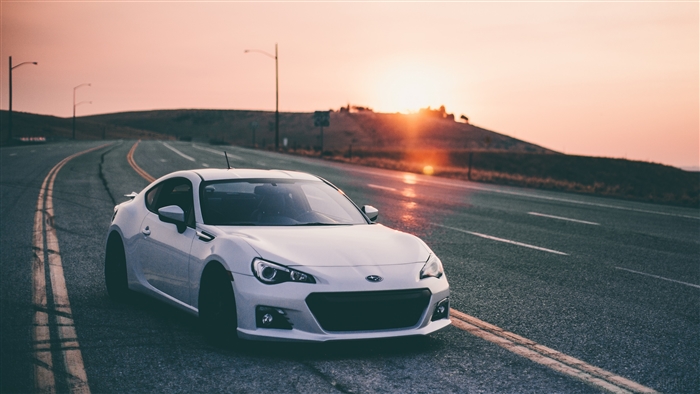 White Subaru BRZ on a road at sunset