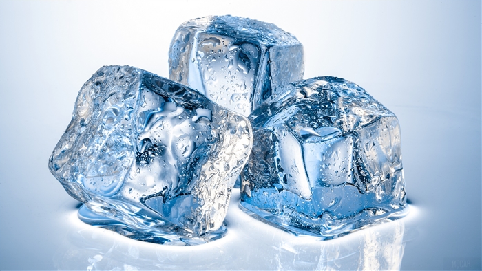 Three ice cubes with water droplets