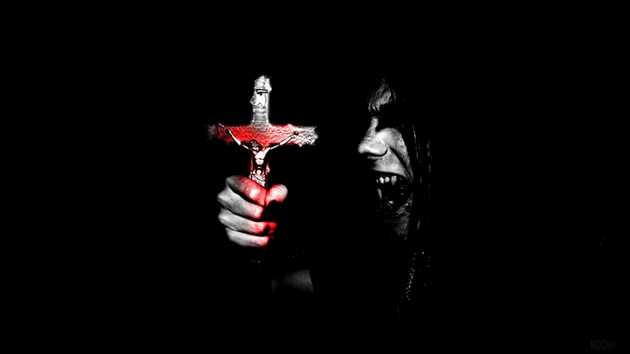 Man holding a bloody crucifix with fangs