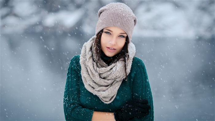 Woman in winter hat and scarf in snow