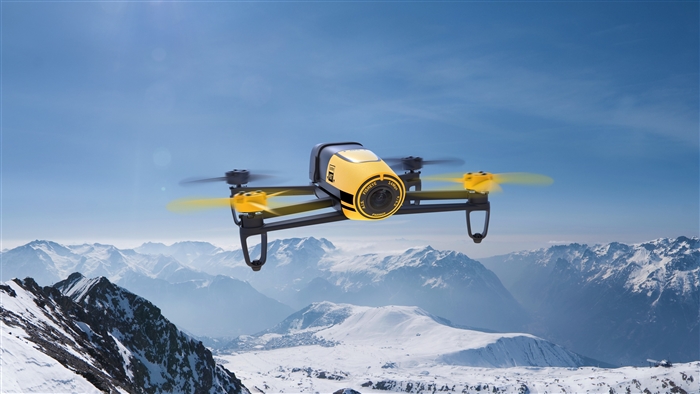 Yellow and black drone flying over snowy mountains