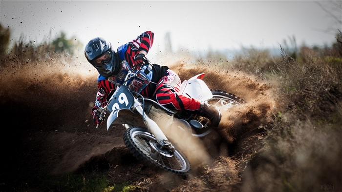 Motocross rider on a dirt bike kicking up dust