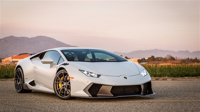 White Lamborghini Huracan on asphalt with mountains