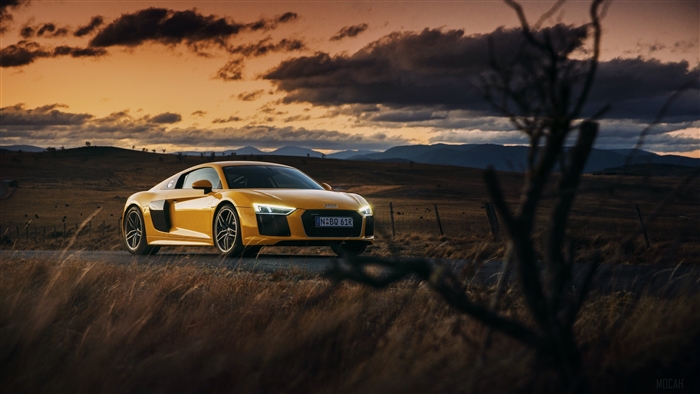 Yellow Audi R8 V10 driving on a rural road at sunset