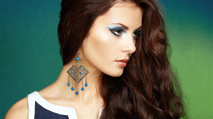 Woman with blue eyeshadow and large earrings