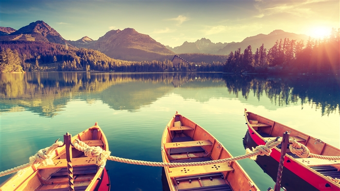 Boats on a lake with mountains and forest